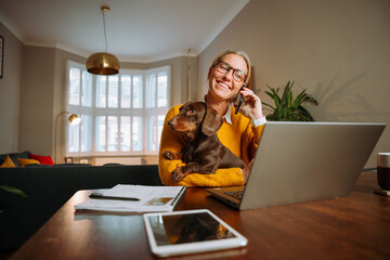 Caucasian female business woman working at home with pet dog