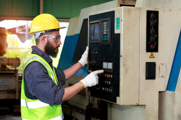 Male engineer wearing a control safety helmet Planning for the maintenance of metal machinery in industrial plants