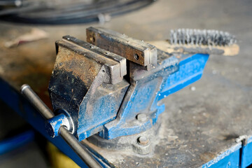 A workplace with metal grips attached to the table. Industrial background.