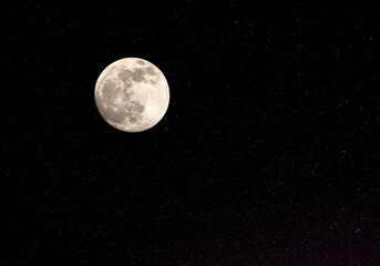 Fototapeta na wymiar Full moon and stars against a black night sky.