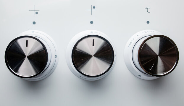 White, black, switch on the electric stove close-up. Close Up Of Knobs Switch Of White Gas Stove. Control knobs of a white, black electric stove close-up. Soft focus