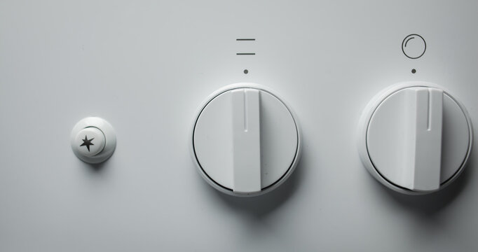 White, black, switch on the electric stove close-up. Close Up Of Knobs Switch Of White Gas Stove. Control knobs of a white, black electric stove close-up. Soft focus