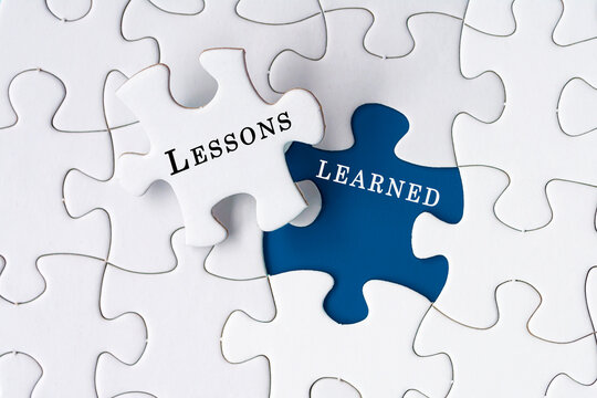 Lessons learned text on Jigsaw Puzzle over blue background.