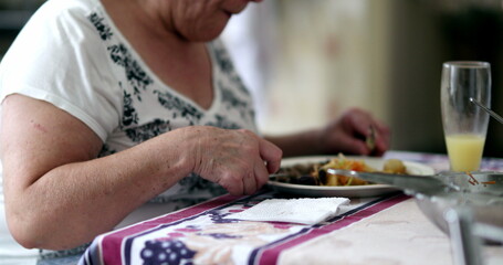 Fototapeta na wymiar Senior woman eating lunch, casual older person at kitchen eating meal