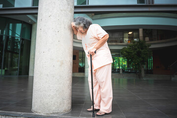 An Asian elderly woman standing and catch a pole Because she has a faint face Dizziness From...