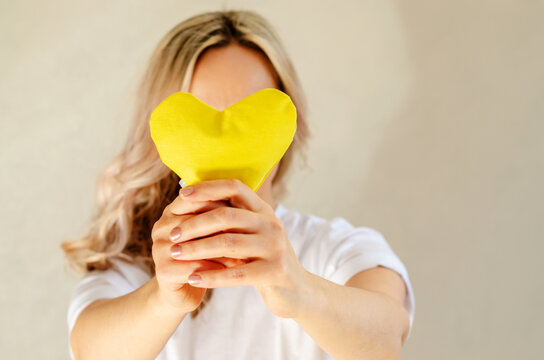 Woman with yellow heart. Concept of love, awareness, yellow September. Selective focus