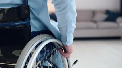 Close up focused view. Moving forward. Disabled man is in the wheelchair at home