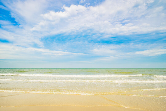 Sea and ocean wave on the sandy beach under blue sky and white clouds, Haad Phetch Beach, Phetchaburi province, Thailand