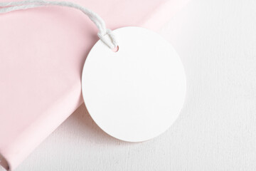 Round white gift tag mockup on pink background. Blank paper circular price sticker tag mockup, Sale...