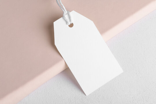 Rectangle White Gift Tag Mockup With White Cord, Close Up On Beige And White Background. Blank Paper Rectangular Price Tag Mockup, Sale And Black Friday Concept, Element For Design, Label Mockup