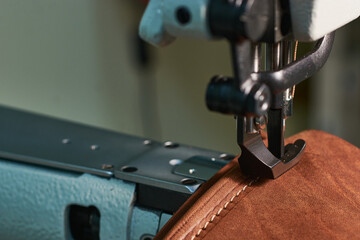 Old scissors in a vintage leather case on a natural leather background.
