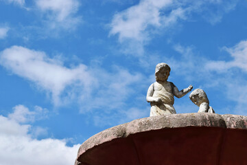 Fuente de piedra con fondo de cielo azul. Espacio para texto al lado izquierdo.