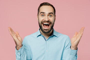 Young surprised amazed fun shocked caucasian man 20s wear classic blue shirt spread hands look camera say wow isolated on plain pastel light pink background studio portrait. People lifestyle concept. - obrazy, fototapety, plakaty