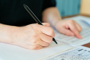 Close up of hand with pen writing at desk in office