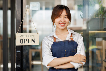 Portrait of a positive Asian businesswoman standing at the cafeteria door entrance. A cheerful...