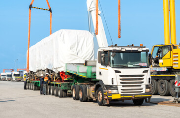 new electric diesel locomotive On the truck, waiting to be lifted onto the rails at the port  using  2 cranes lifting diesel-electric locomotives