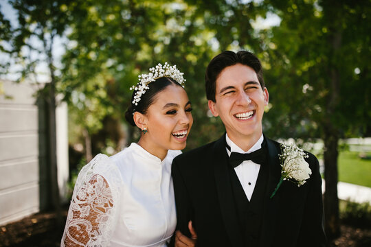 Multiracial groom and bride laughing after wedding ceremony