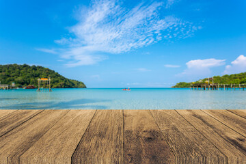 Wood table top on blue sea with sky background, can place your products for display ,concept of beach and summer