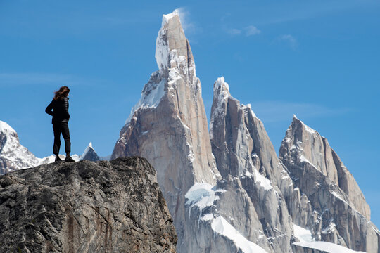 A hiker silhouetted against the massive peaks of Cerro Torre