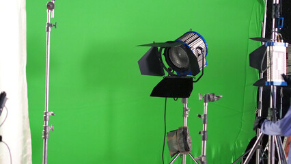 Big studio LED spotlight for video movie or photo film production with green screen background for...