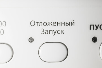 Button to turn on the function of delayed start of washing. Control panel of the washing machine. Russian interface. Selective focus. Text to translate Russian - Delayed Startup
