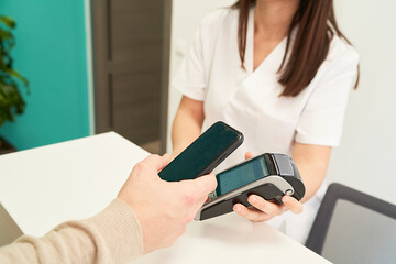 patient paying the visit to the physiotherapist by credit card