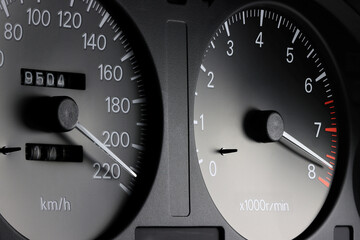 tachometer and speedometer in car dashboard at full power