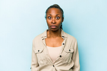 Young african american woman isolated on blue background sad, serious face, feeling miserable and displeased.