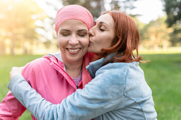 women hugging with closed eyes while kissing the fighter against cancer - concept fight against...