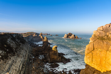 Fototapeta na wymiar The spectacular rock formations on the shore of the Cantabrian coast at sunrise, Flysch at Costa Quebrada, Liencres, Cantabria, Spain