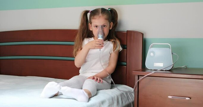 Girl making inhalation with nebulizer at home.