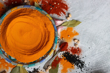 Turmeric powder close up photo. Curcuma spice on beautiful blue ceramic plate. Indian spices texture. Colorful still life with turmeric. 