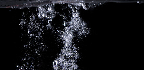 Blurry images of clear transperant soda liquid bubbles splashing or sparkling and moving up in...