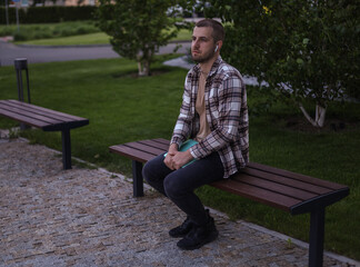 Obraz premium The guy is sitting near office buildings and working on a laptop
