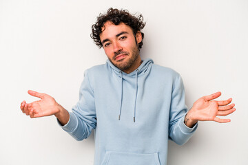 Young caucasian man isolated on white background doubting and shrugging shoulders in questioning...