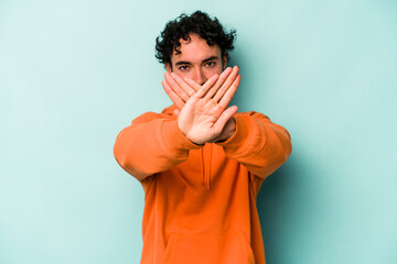 Young caucasian man isolated on white background doing a denial gesture