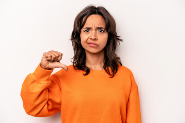 Young hispanic woman isolated on white background showing a dislike gesture, thumbs down....
