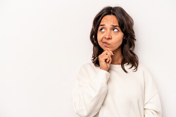 Young hispanic woman isolated on white background looking sideways with doubtful and skeptical expression.