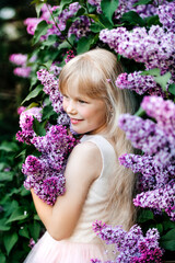 blonde girl in lilac bushes