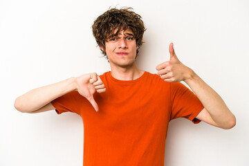 Young caucasian man isolated on white background showing thumbs up and thumbs down, difficult...
