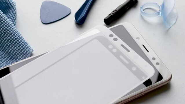 maintenance and repairing smartphones. glass screen protector holded above mobile phone, replace concept. concept. mobile screen replacement protector,repair kit. installation of protective