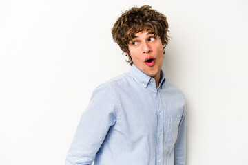 Young caucasian man isolated on white background looks aside smiling, cheerful and pleasant.