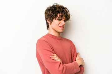 Young caucasian man isolated on white background frowning face in displeasure, keeps arms folded.