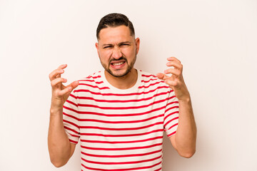 Young hispanic man isolated on white background upset screaming with tense hands.