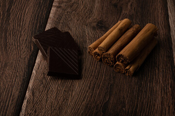 Chocolate and cinnamon on a dark wood background