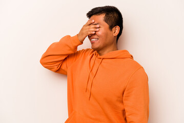 Young hispanic man isolated on white background covers eyes with hands, smiles broadly waiting for a surprise.
