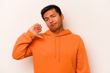 Young hispanic man isolated on white background showing a dislike gesture, thumbs down....