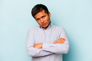 Young hispanic man isolated on blue background who is bored, fatigued and need a relax day.