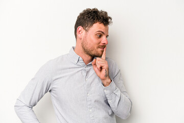 Young caucasian man isolated on white background keeping a secret or asking for silence.