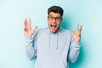 Young caucasian man isolated on blue background screaming to the sky, looking up, frustrated.